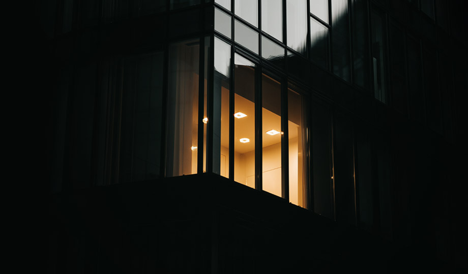 One lit office window among dark ones, at night